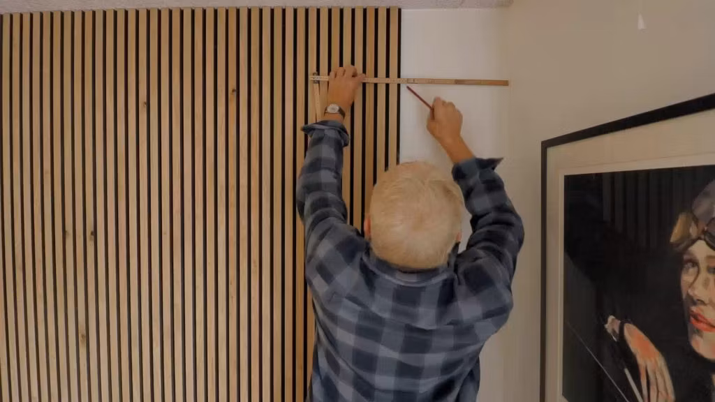 Hombre instalando paneles acusticos en una pared